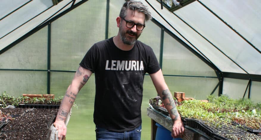 Kellen in front of plants in hoop house