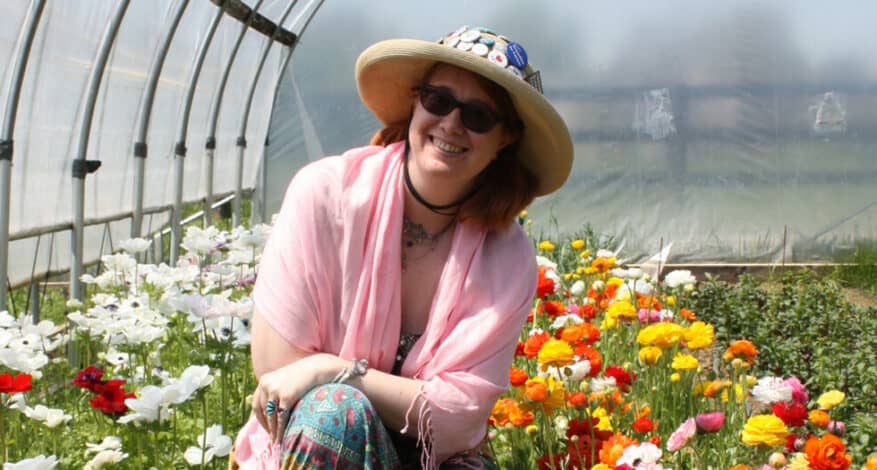 Tabitha Dial in front of flowers in the hoop house