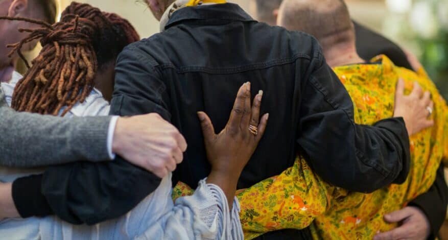 five people embracing each other