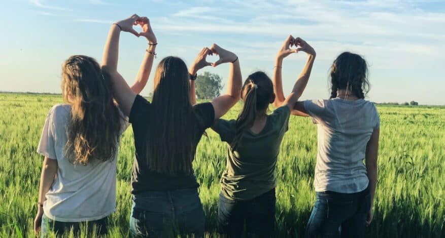 teenagers field making hearts with hands