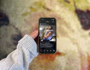 holding up phone showing instagram post